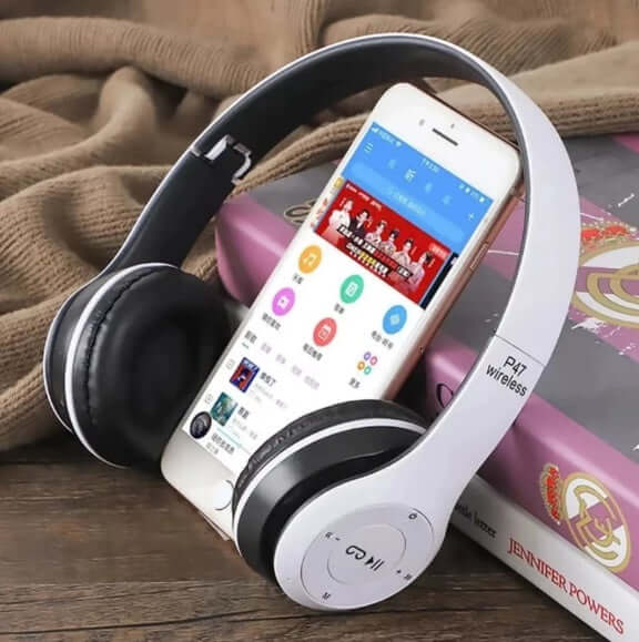 Wireless Headphones Briame P47 - Red placed next to a smartphone displaying music app interface on a wooden surface.